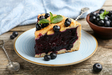 Slice of homemade blueberry pie on wooden table, closeup
