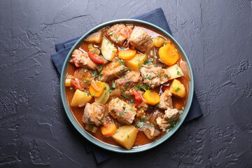 Delicious stew with vegetables on black table, top view