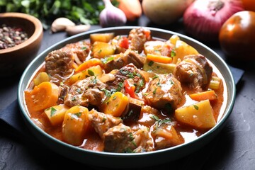 Delicious stew and different ingredients on table, closeup
