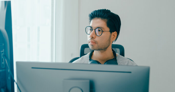 Young adult Asia male freelance eyeglasses typing write prompt AI bot IT app smart program nomad, video game, terminal with coding, user interface, designer, big data center on desktop computer.