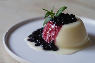 Panna cotta dessert with blueberry sauce and fresh mint. Close-up.