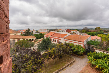Obraz premium View from a castle vantage point over a peaceful courtyard and the terracotta rooftops of a Portuguese town.