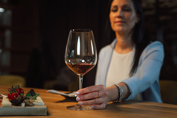 Woman tasting wine at the wine cellar with barrels in background