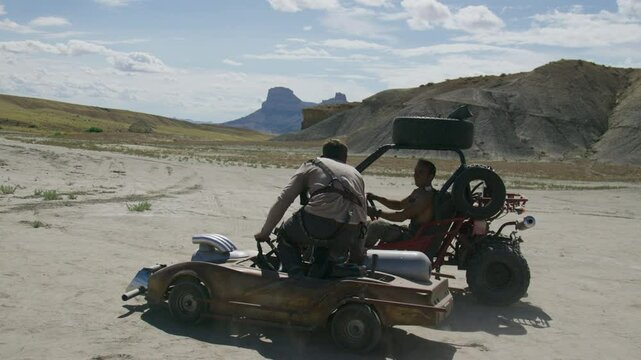 Stunt guy commandeering man's gokart in apocalyptic wasteland