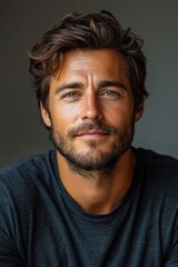 Fototapeta premium A man with a relaxed expression poses, showcasing his casual style and confident demeanor in soft lighting