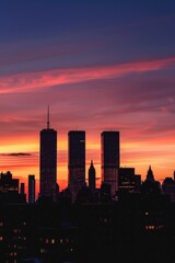 A city skyline at sunset with vibrant colors and long shadows