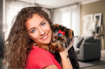 Young woman petting her cute dog at home