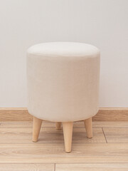 Round light pouf with wooden legs. Vandal-proof upholstery