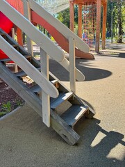 A wooden playground structure with a shadow cast on the ground