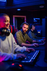 Gamers sitting in gaming room and playing online video games.