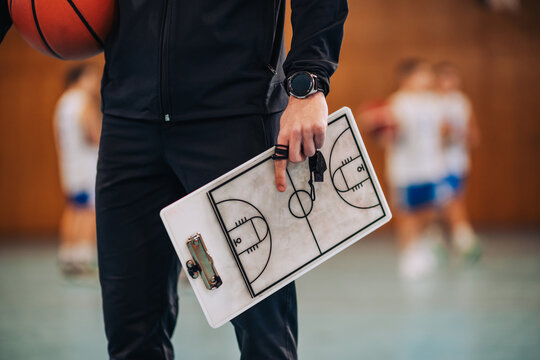 Coach holding basketball playbook