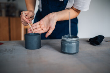 Close up of professional female potter gluing earthenware at workshop.