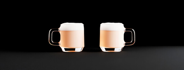 Obraz premium Two glass mugs filled with foamy beer are placed side by side on a dark surface. The light brown color of the beer contrasts vividly with the dark background.