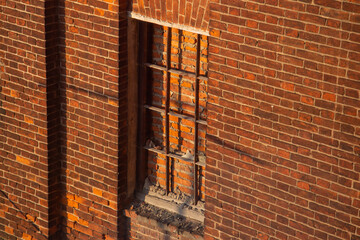 An old brick wall with a closed window