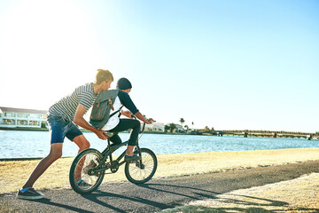 Outdoor, boys and push with bicycle for learning, paddle and coordination with balance by space....
