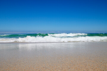 Welle am Strand bei blauem Himmel