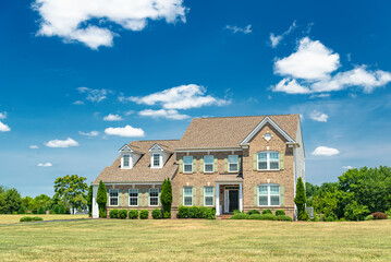Landscape with large country house. Large mowed lawn and blue sky.