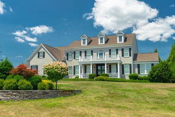 Landscape with large country house. Large mowed lawn and blue sky.