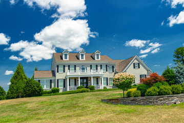  large country house under blue skies. Landscape with garden design, lawn and clouds.