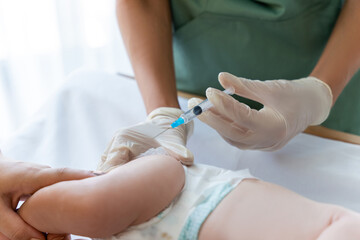 Pediatrician administers an injection to baby during routine checkup at hospital