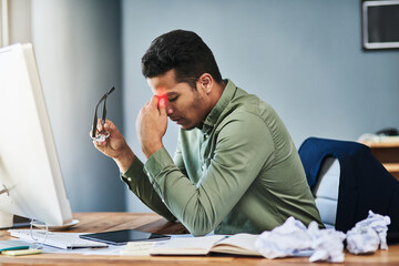 Man, stress and headache in office by computer with glass, pain or red glow with chaos at company....