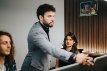 A focused business team in a modern office environment works together discussing project tasks and solutions to improve efficiency.