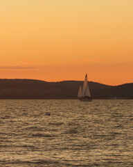 sailboat at sunset, calm and peaceful