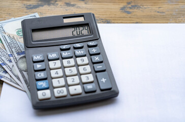 Calculator with the number 2024 on the display US dollars. Concept of finance, taxes, savings and economic crisis.