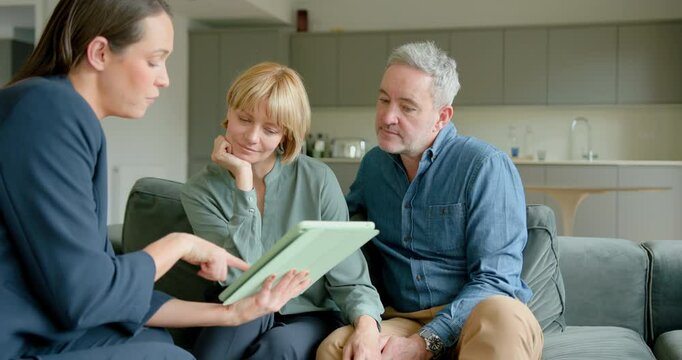 Mature Couple Meeting with a Financial advisor in their Home, looking at Digital tablet