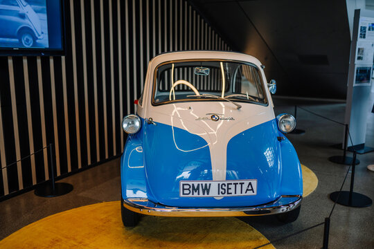 Munich, Germany - September 13, 2024 -  A vintage blue and white BMW Isetta microcar displayed in a showroom, showcasing its compact design and retro styling.