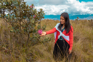 Campesina peruana atractiva con manta artesanal en la chacra,con flores, estilo de vida y vestimenta tradicional.Quechua.aire libre