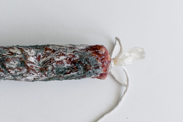 Green and white mold on spoiled dry sausage. Close-up.