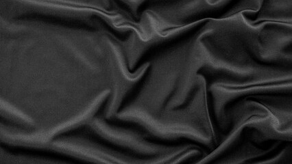 A detailed close-up of black fabric with natural creases and folds, capturing its smooth texture and subtle sheen. Ideal for fashion, fabric patterns, or background designs