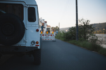 A white SUV is parked near the river