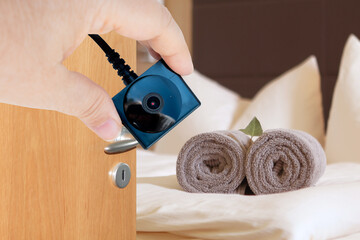 room hotels, apartments, person holding tiny spy surveillance camera, illegally installation hidden...