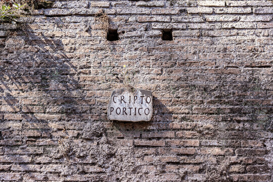 Cripto Portico sign on a weathered ancient brick wall at the Roman Forum in Rome