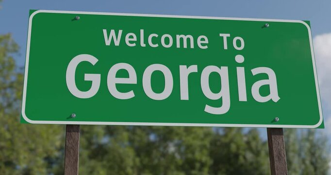Driving By A Welcome To Georgia Green Road Sign Against a Blue Sky and Clouds.
