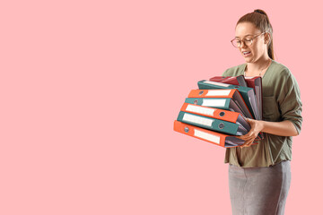 Young woman with document folders on pink background