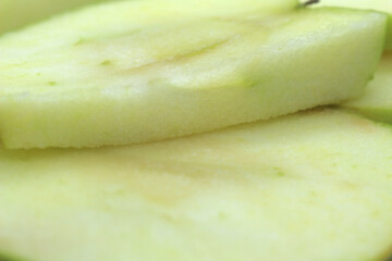 sliced green apple. apple slices. apple background. close up on apple. one slice on top of another.