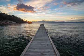 Jetty leading into a bay and a peaceful sky