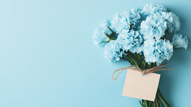 Beautiful light blue carnation flower arrangement with tied string with 'Happy Birthday' inscription, placed on blue pastel background