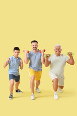 Obraz premium Sporty teenage boy with his dad and grandfather training on yellow background
