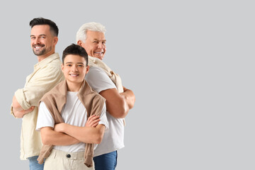 Teenage boy with his dad and grandfather on light background