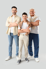 Teenage boy with his dad and grandfather on light background