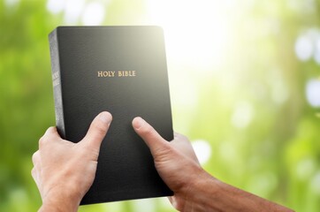 Christian person hands hold Holy Bible book