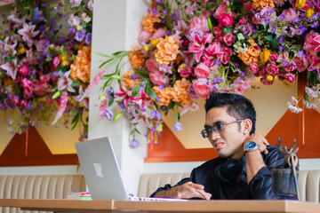 handsome asian male businessman in pain shoulder pain in front of laptop computer on table, sitting in cafe workplace. for health, education, technology, lifestyle content