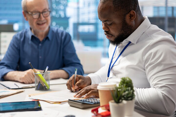 Financial advisor signing the retirement plan contract at the end of the agreement between senior people and the insurance agency. Agent helping couple to secure their pension.