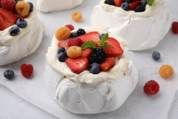 Pavlova cake (meringue dessert) with whipped cream and fresh berries on table, closeup