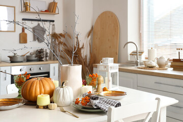 Autumn table setting with pumpkins in kitchen