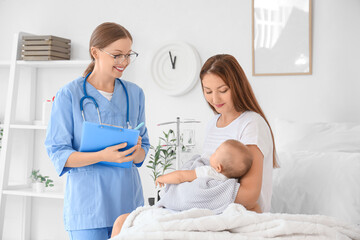 Young mother with newborn baby and nurse in maternity hospital